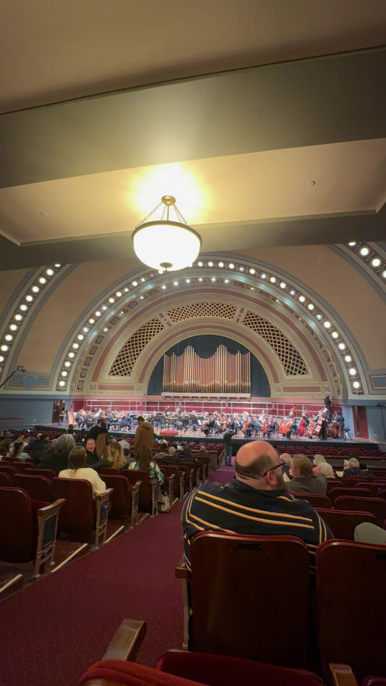 The U-M Chamber Choir, Orpheus Singers, University  Choir, and University Symphony Orchestra performing on stage at Hill Auditorium.