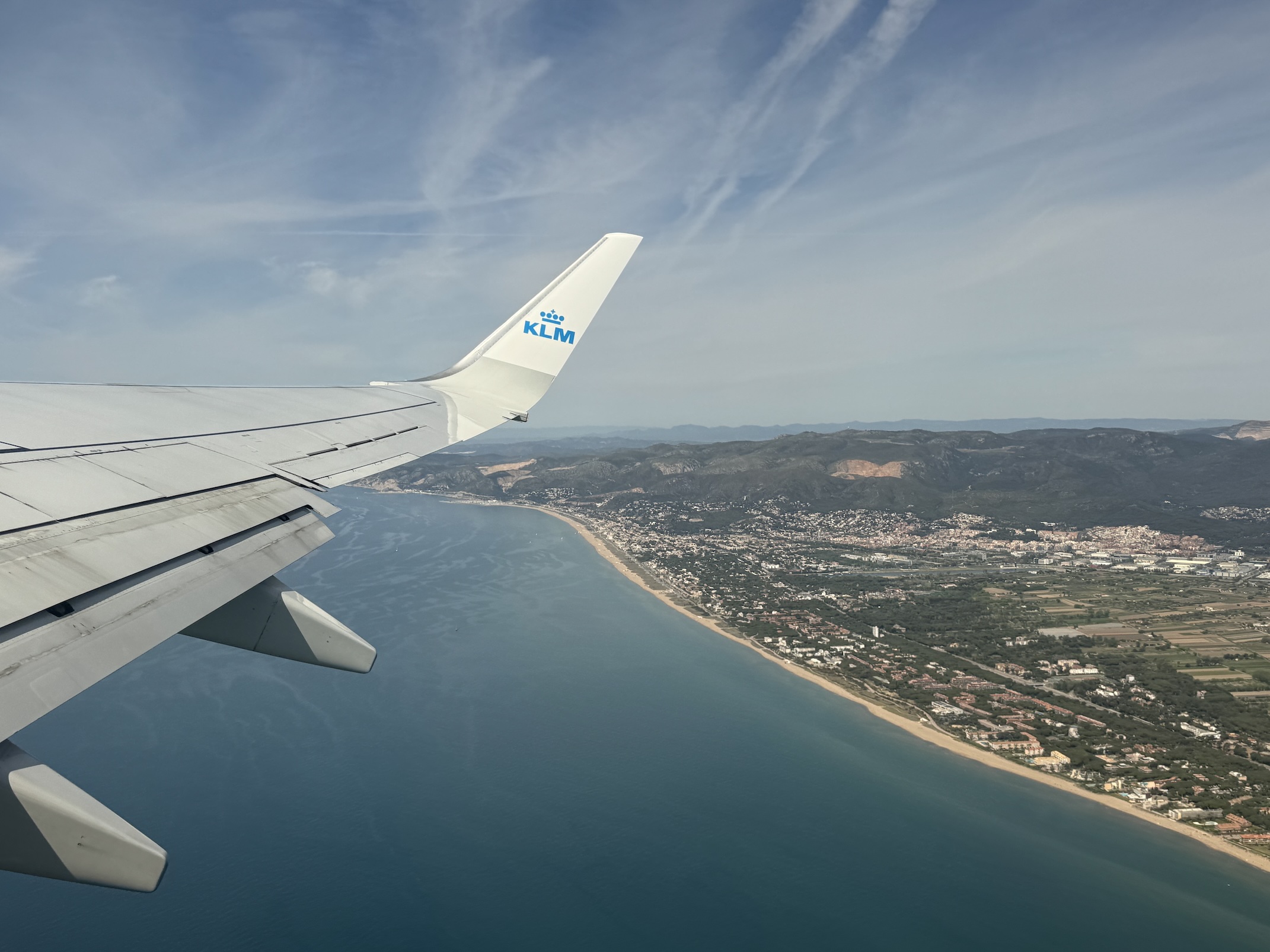 View of the Barcelona shoreline from inside an airplane.