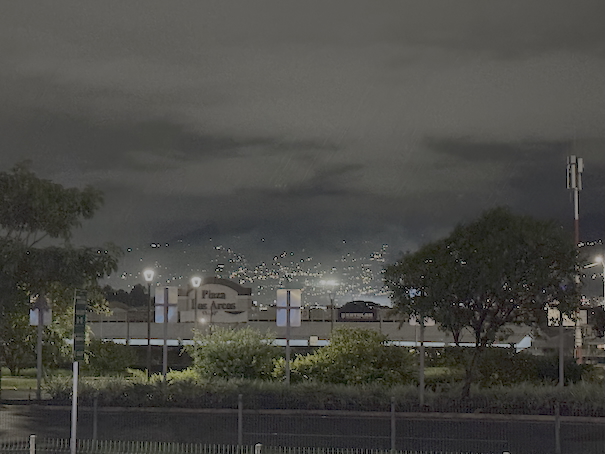 nighttime photo of distant city lights between large mountains; San Jose, Costa Rica